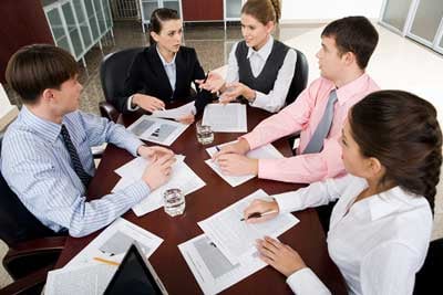 Group of individuals talking at a table during a meeting