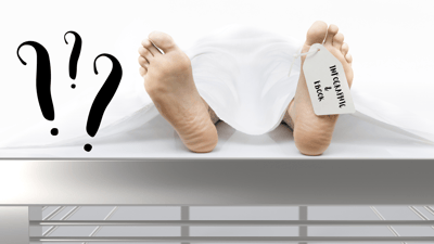 body with toe tag on silver table black question marks infographics & ebooks on tag
