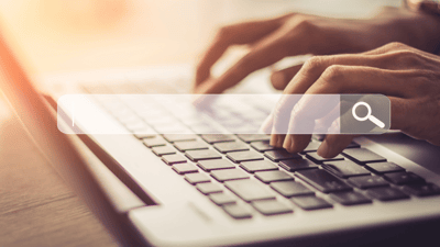 feminine hands on a laptop keyboard, search bar image superimposed 