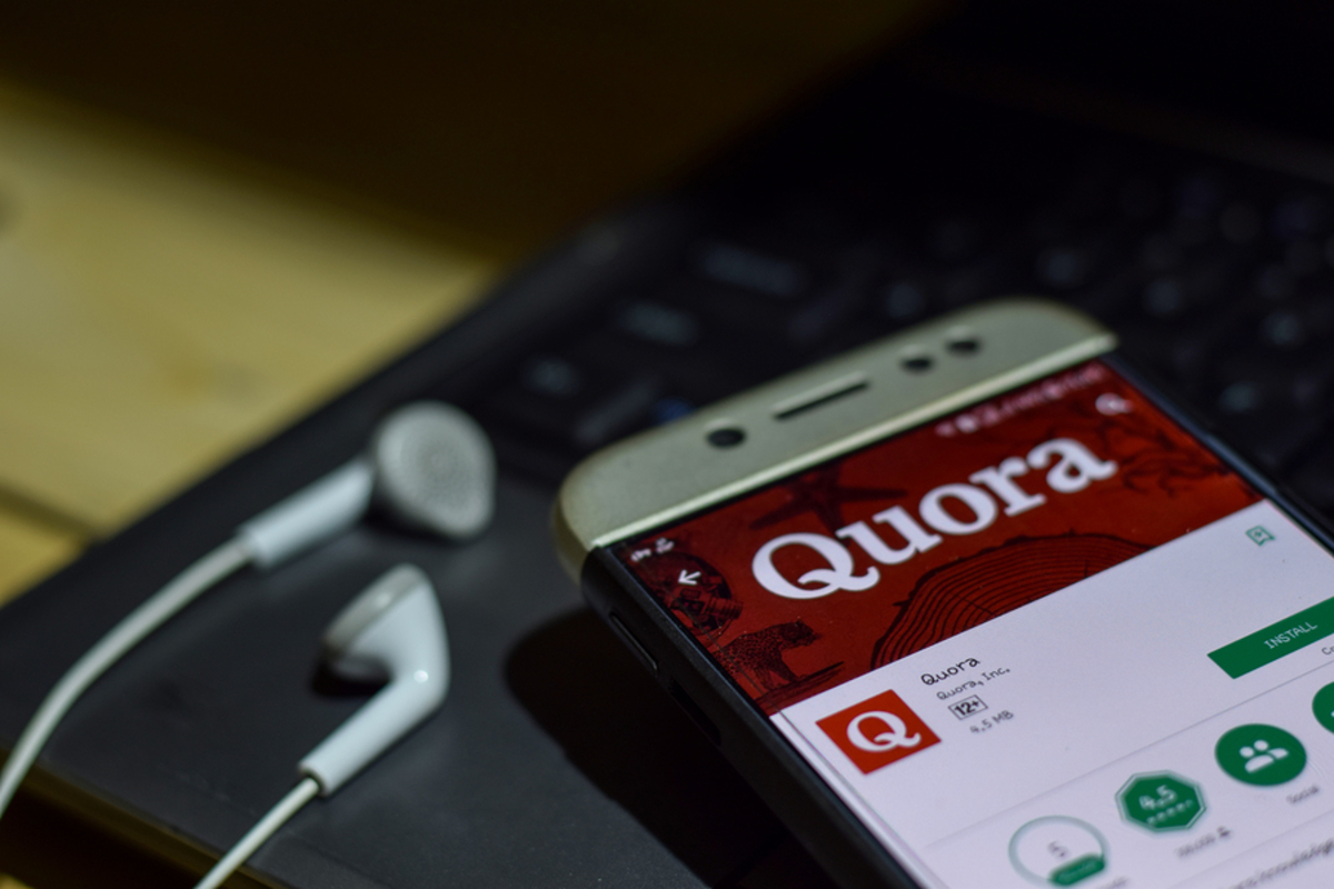 Phone with Quora app displayed.