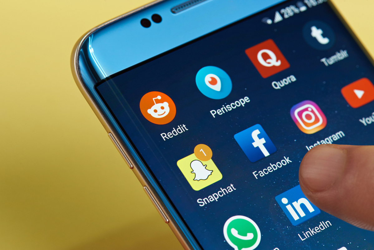 Phone with social media icons displayed.