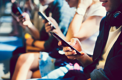 People sitting down using their cell phones.