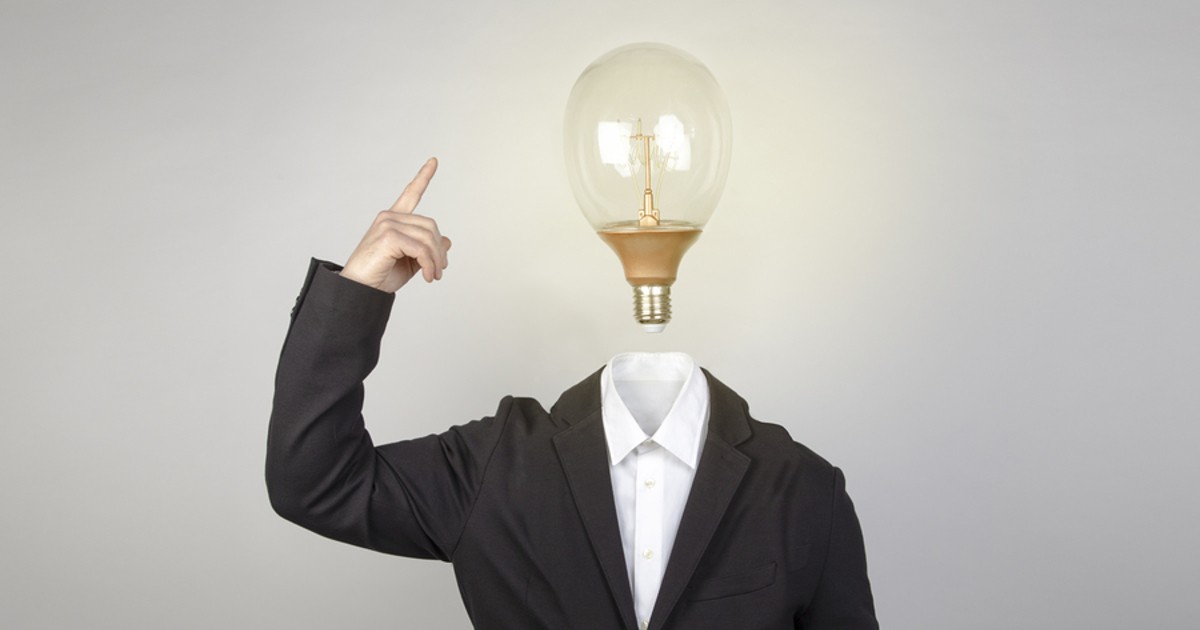 Person standing with a lightbulb in place of a head.