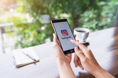 Person looking at the instagram app on their phone.