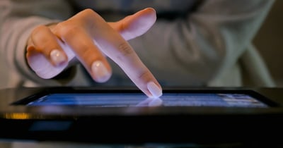 feminine hand touching tablet screen