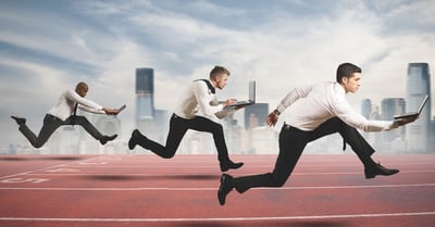 3 Men holding laptops running a foot race
