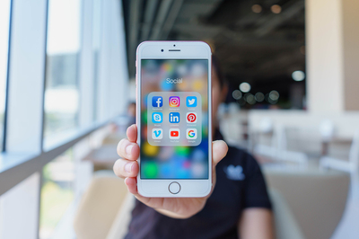 Mobile phone with social media apps displayed.